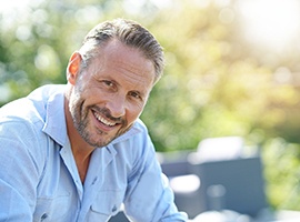 Man sitting outside on a sunny day while smiling