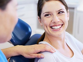 a woman smiling while visiting her dentist