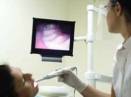 Dentist and dental patient looking at intraoral photos